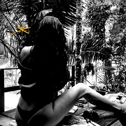 Amy, an OnlyFans model, poses in a tropical location. 🌴