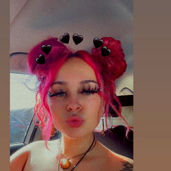 Jayy, a vibrant and colorful influencer with pink hair and red accessories