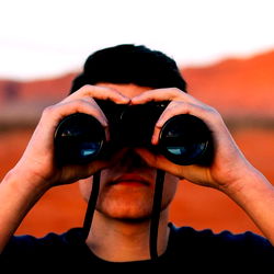 An Individual Peering Through Binoculars