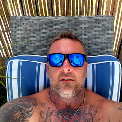 Shirtless Man in Sunglasses Taking a Break