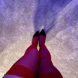 Elegant Model in Red Lingerie and High Heels Against Blue Carpet