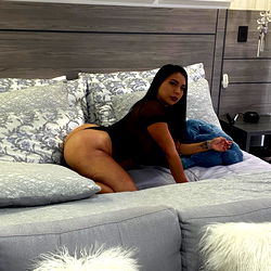 Andrea, a Latinx model on OnlyFans, in a luxurious bedroom setting