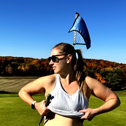 Casually Dressed Woman Unbuttoning Her Tank Top on a Golf Course
