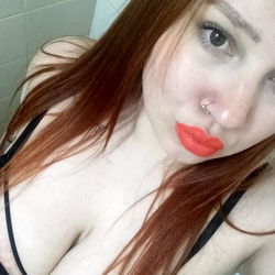 Model with vibrant red hair and bold lipstick