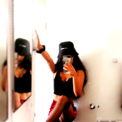 Young Woman in Stylish Attire Posing in Bathroom Mirror