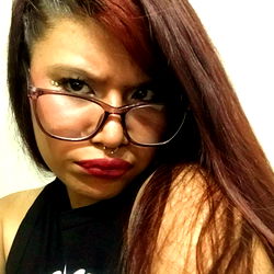 Stylish young adult with long red hair, glasses and a strong presence in the OnlyFans community.