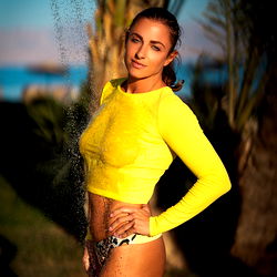 Model posing in vibrant yellow top by pool