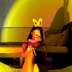 Model pose in vibrant room with phone