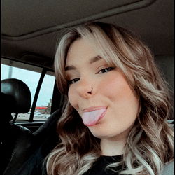 Candid Moment of a Smiling Woman with Tattoos and Nose Piercing