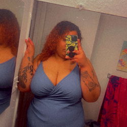 Plus Size Model in Blue Dress Standing in Front of Mirror