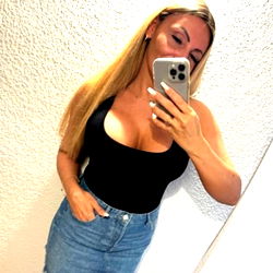Woman in a Tank Top and Jeans Taking a Selfie