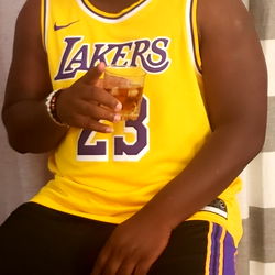 A Young Man Sitting with a Beverage and a Basketball Jersey