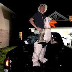 Hilarious Halloween Costume: Man Dressed as a Turkey with a Duck's Head and a Person on Top