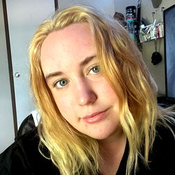 Emma Dawn, a young adult female with long blond hair posing for an OnlyFans photo