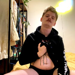 August Adams - OnlyFans Model, Striking Pose in Racy Outfit