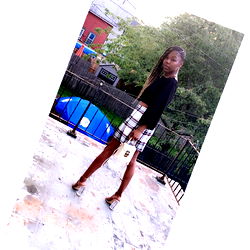 Woman in a Plaid Skirt Standing Outdoors