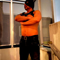 A shirtless man in a room, possibly posing for the camera or on a set