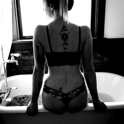 Model in Bathroom Sitting on Bathtub