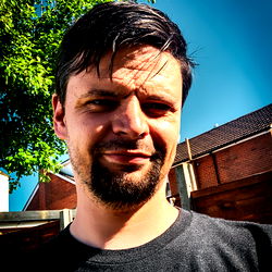 A Serious Expression on a Man's Face in a Grey Skirt