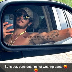 Andre M, a Michigan-based OnlyFans model poses confidently for a selfie in his car, showcasing his unique style and athletic build. He's captured on a sunny day in the heart of Michigan.