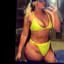 Juju, a swimsuit model, sharing a mirror selfie with her followers on Instagram. Her outfit is vibrant and summery, perfectly fitting for her poolside location.