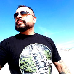 Strong and Tattooed Man on Beach