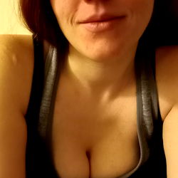 Woman with Tattoos Smiling in Her Bedroom