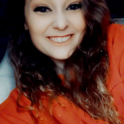 A young woman with red hair and a wide smile