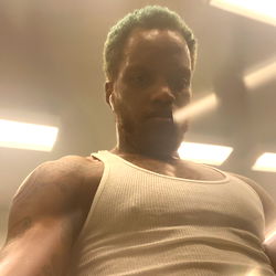 A Muscular Man with Green Hair in a Gym