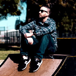 A Man Sitting on a Skateboard Ramp