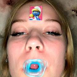 Woman Making Playful Tongue Gesture with Blue and Red Oddly Shaped Oblongs