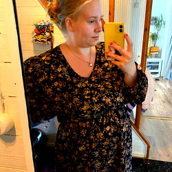 A Stylish Woman in a Floral Dress Poses with her Phone