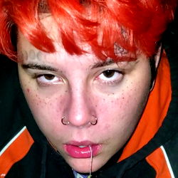 Red-haired individual in a playful pose with tongue out