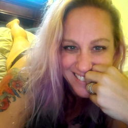 Whitney, a tattooed beauty relaxing in bed