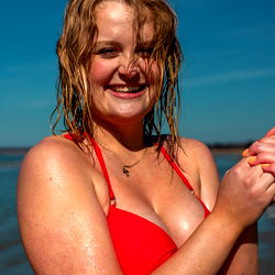 Smiling Woman in Red Swimsuit at Beach