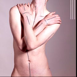 Fashion-forward androgynous Sydney model showcasing a tattooed chest with hand-stitched detailing the seams in his ribs. 