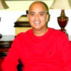 MichCon, a Florida influencer with bald head and red shirt sitting in a home office