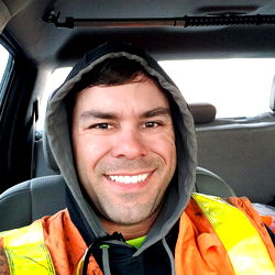A Construction Worker Smiling Behind the Wheel