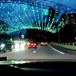 A Car Dashboard at Night with a Cityscape in the Background,