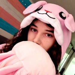 A model in a pink hoodie with a bunny hat and a stuffed animal.