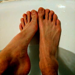 A Man's Feet in a Bathtub