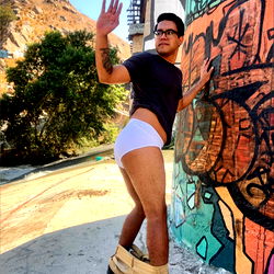 Young Man in Underwear Posing on Graffiti-Covered Wall