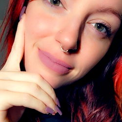 Alicia, a vibrant individual with striking red hair and bold pink lipstick