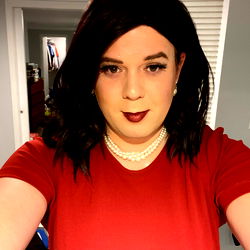 A person taking a mirror selfie in a red top