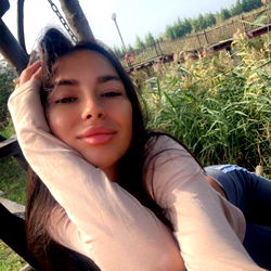 Missy Saint, a young woman with long hair relaxing in a hammock outdoors.