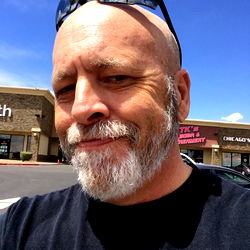 Man with beard and sunglasses in front of storefront, Sin City Las Vegas