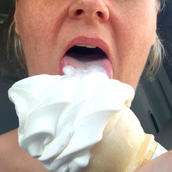 Amybbclove1, a Southeast United States model, is seen licking a white ice cream cone with joy.