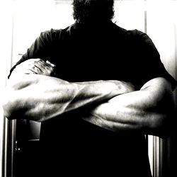 Strong and Muscular Man in Black T-Shirt, Arms Crossed