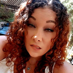 Woman with curly hair and smoky makeup