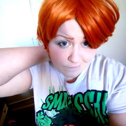 Red-haired cosplayer with exaggerated wig, posing for a photo